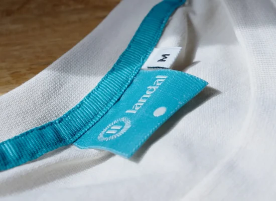 Close-up van een Landal kledinglabel aan een wit kledingstuk.