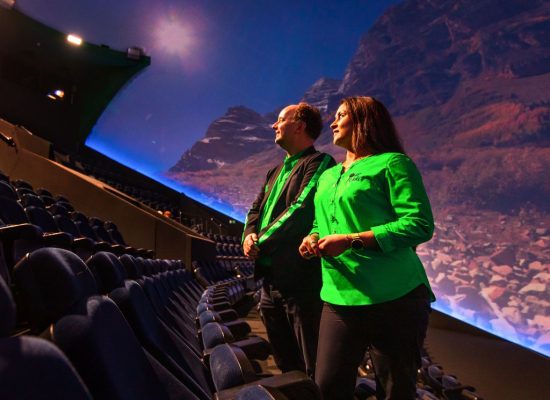 Bedrijfskleding One Planet Jas/vest, blouse en broek Medewerkers die uitkijken op een bioscoopzaal